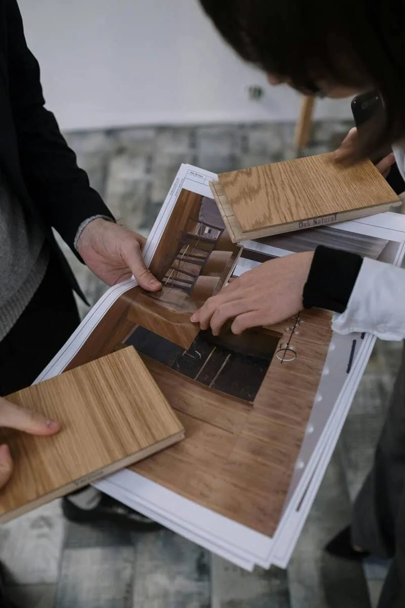 Group of architects reviewing interior design plans and wood samples for a new project.